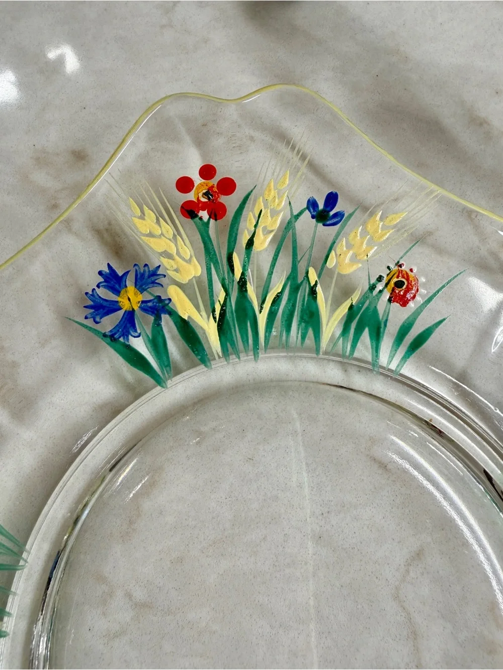 7 1/4” CLEAR GLASS PLATES WITH A COLORFUL, HAND-PAINTED DESIGN & YELLOW TRIM.